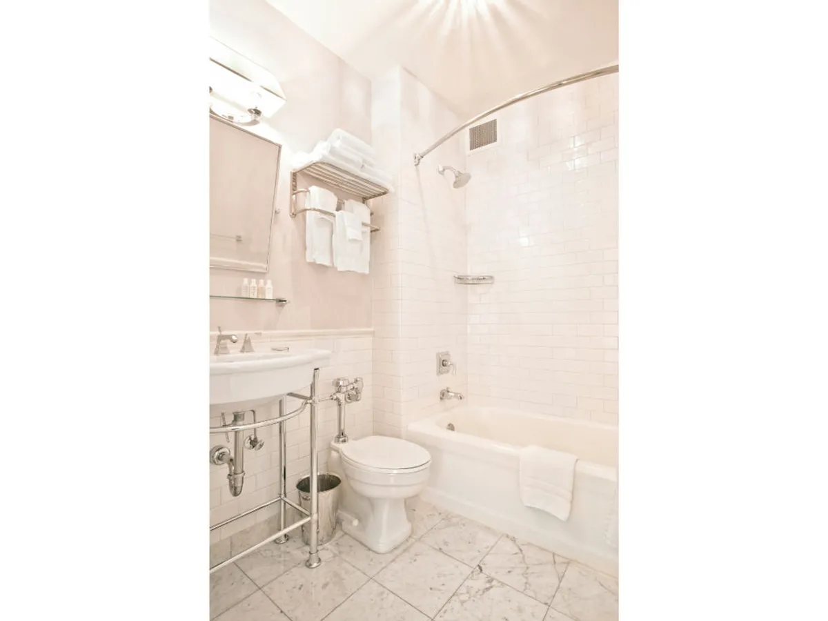An elegant bathroom interior focused on a vanity sink, bathtub, and shower area with neatly arranged towels. The setting feels refreshing and calm, ideal for self-care routines and personal rejuvenation.